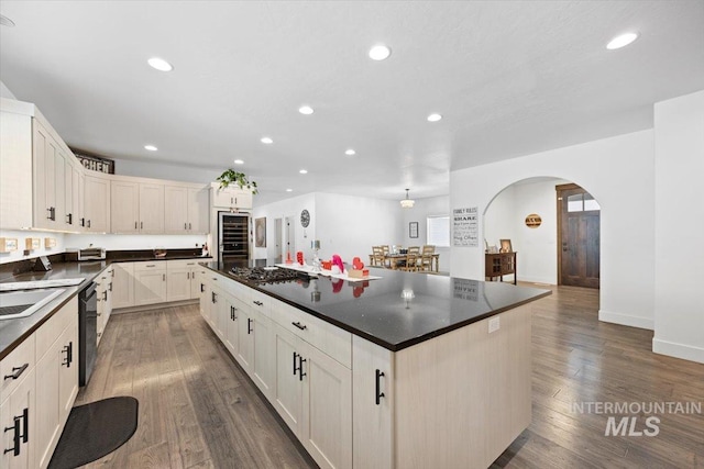 kitchen with dishwashing machine, dark wood-type flooring, a center island, and stainless steel gas stovetop