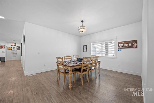 dining area with hardwood / wood-style flooring and a chandelier