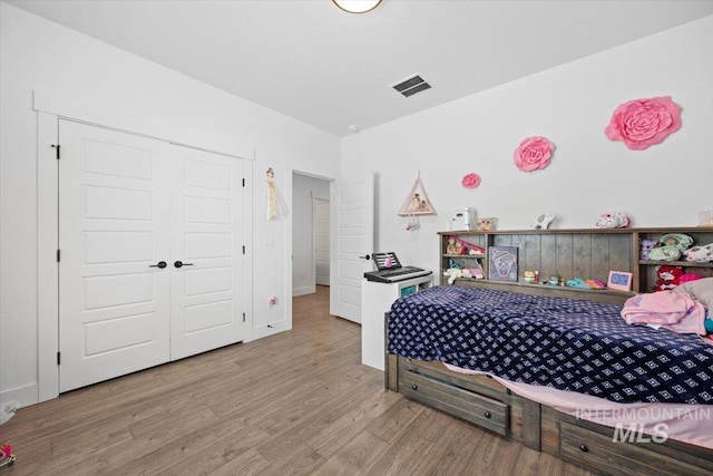 bedroom featuring wood-type flooring and a closet