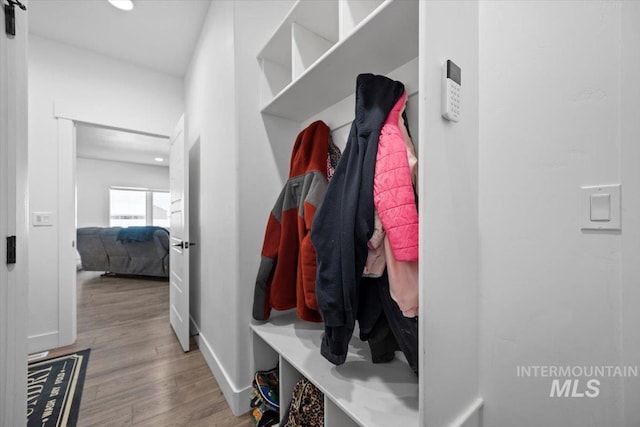 mudroom with a barn door and light wood-type flooring