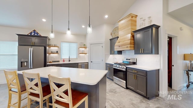 kitchen featuring a kitchen breakfast bar, backsplash, custom exhaust hood, stainless steel appliances, and decorative light fixtures