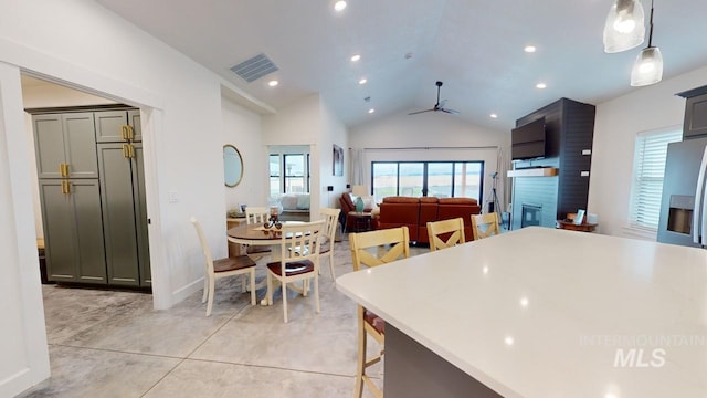 kitchen with a kitchen bar, ceiling fan, decorative light fixtures, gray cabinets, and lofted ceiling