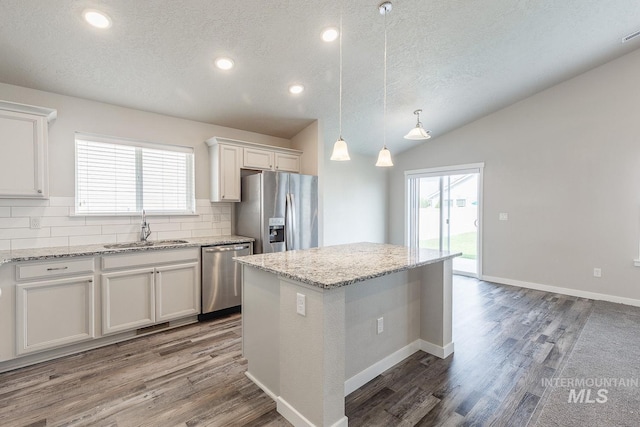 kitchen with decorative backsplash, white cabinetry, appliances with stainless steel finishes, and a sink