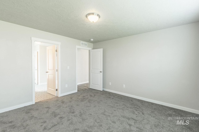 unfurnished bedroom with visible vents, baseboards, carpet, and a textured ceiling