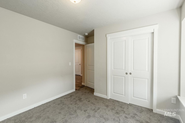 unfurnished bedroom with carpet, visible vents, a closet, and baseboards