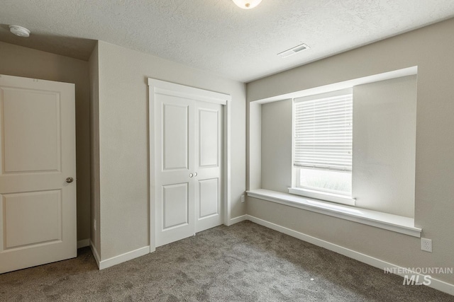unfurnished bedroom with a closet, baseboards, visible vents, and carpet floors
