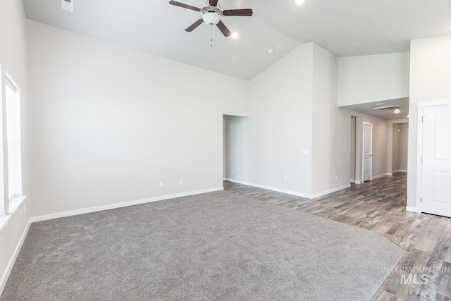 spare room featuring baseboards, high vaulted ceiling, ceiling fan, and wood finished floors