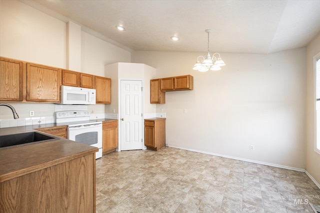 kitchen with high vaulted ceiling, sink, hanging light fixtures, white appliances, and an inviting chandelier