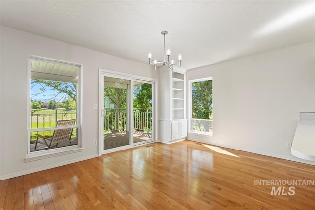 975 W Meander Ct, Eagle, ID 83616 - unfurnished room with a chandelier, wood finished floors, baseboards, and built in features