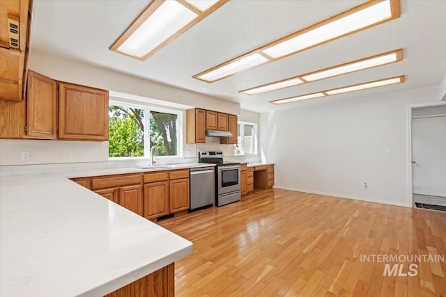 975 W Meander Ct, Eagle, ID 83616 - kitchen featuring appliances with stainless steel finishes, brown cabinets, light countertops, and light wood-type flooring
