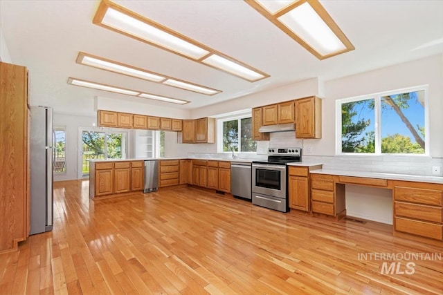 975 W Meander Ct, Eagle, ID 83616 - kitchen featuring stainless steel appliances, under cabinet range hood, light wood finished floors, and decorative backsplash
