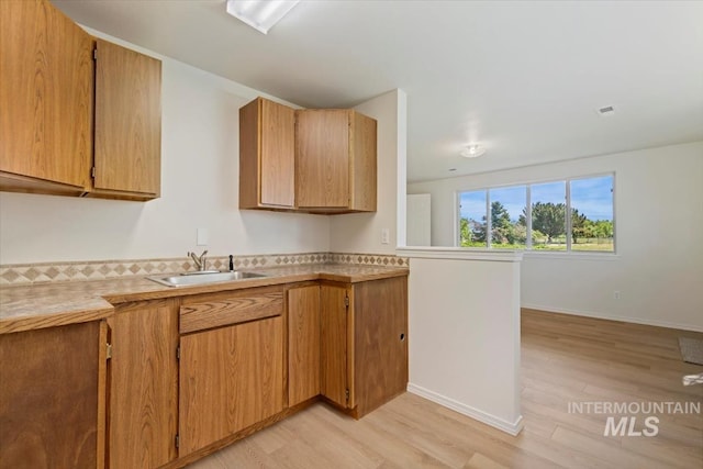 975 W Meander Ct, Eagle, ID 83616 - kitchen with a sink, light wood finished floors, light countertops, and baseboards