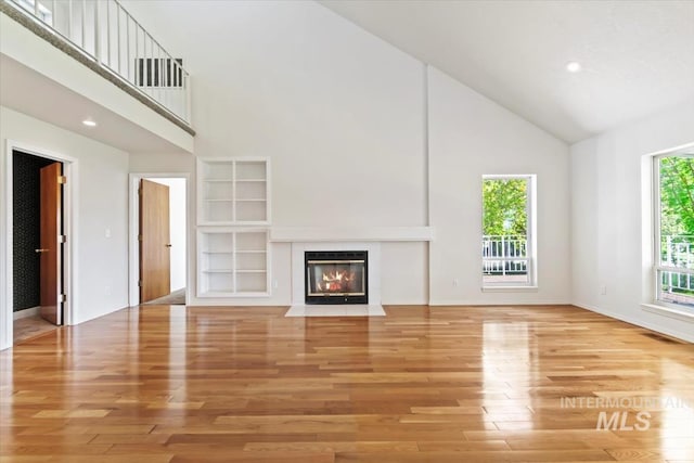 975 W Meander Ct, Eagle, ID 83616 - unfurnished living room with high vaulted ceiling, light wood-style floors, a fireplace with flush hearth, baseboards, and recessed lighting