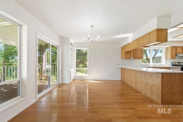 975 W Meander Ct, Eagle, ID 83616 - kitchen with electric stove, light countertops, a chandelier, and light wood-style flooring