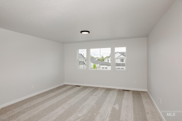 carpeted empty room with a textured ceiling