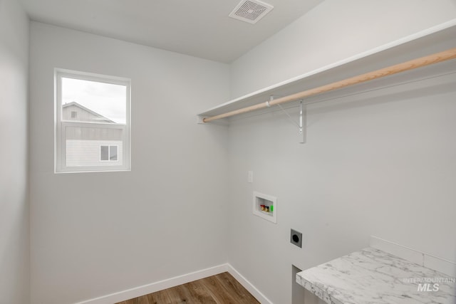 clothes washing area featuring electric dryer hookup, dark wood-type flooring, and washer hookup