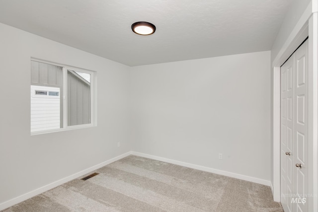 spare room with carpet and a textured ceiling