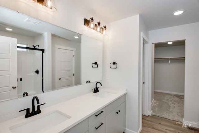 bathroom with vanity, walk in shower, and wood-type flooring