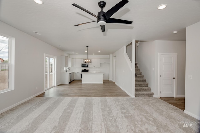 unfurnished living room with ceiling fan