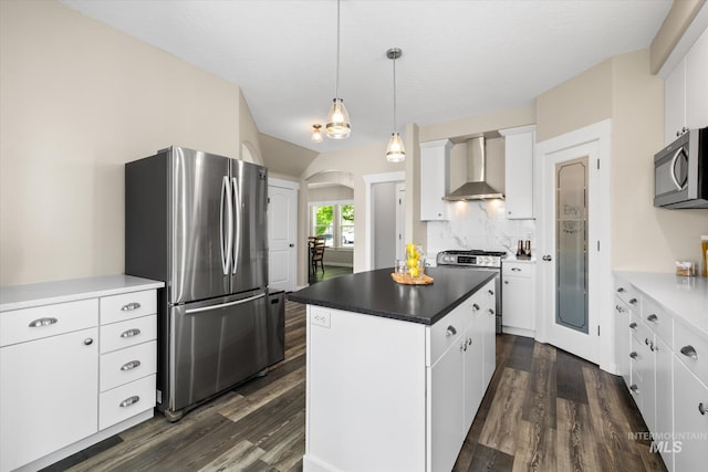12384 S Abbott Downing Way, Nampa, ID 83686 - kitchen featuring appliances with stainless steel finishes, wall chimney exhaust hood, dark wood finished floors, and arched walkways