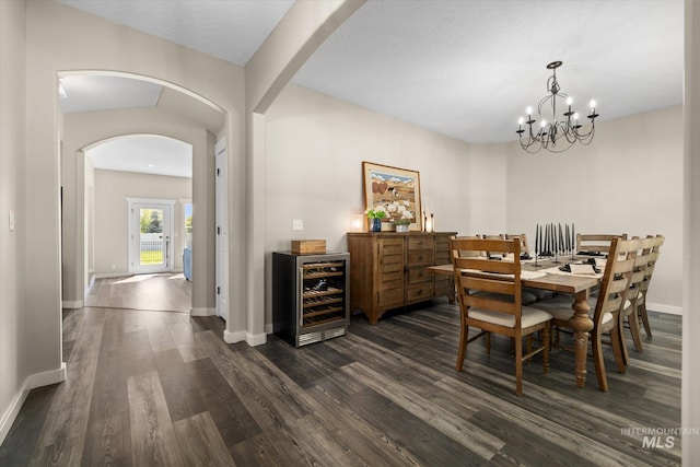 12384 S Abbott Downing Way, Nampa, ID 83686 - dining area with wine cooler, arched walkways, dark wood-style floors, baseboards, and a chandelier