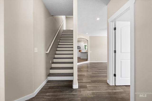 12384 S Abbott Downing Way, Nampa, ID 83686 - staircase with arched walkways, baseboards, wood finished floors, and recessed lighting