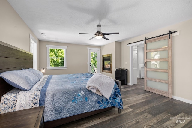 12384 S Abbott Downing Way, Nampa, ID 83686 - bedroom with a barn door, access to outside, dark wood finished floors, baseboards, and ceiling fan