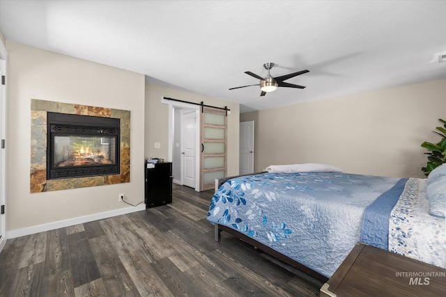 12384 S Abbott Downing Way, Nampa, ID 83686 - bedroom featuring wood finished floors, a barn door, a multi sided fireplace, a ceiling fan, and baseboards