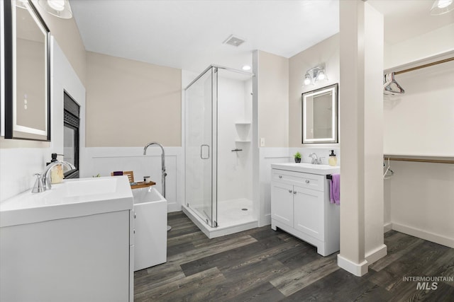 12384 S Abbott Downing Way, Nampa, ID 83686 - full bath with a stall shower, wood finished floors, two vanities, a freestanding tub, and a spacious closet