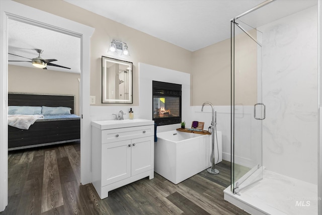 12384 S Abbott Downing Way, Nampa, ID 83686 - ensuite bathroom featuring a shower stall, wood finished floors, a freestanding tub, vanity, and a ceiling fan