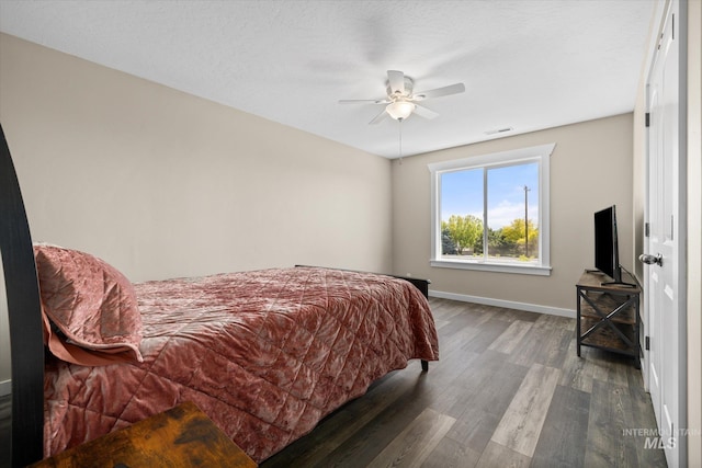 12384 S Abbott Downing Way, Nampa, ID 83686 - bedroom featuring dark wood-style flooring, baseboards, and a ceiling fan