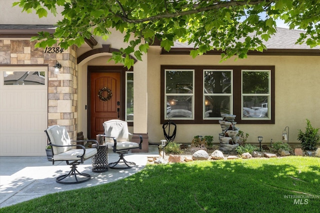 12384 S Abbott Downing Way, Nampa, ID 83686 - property entrance featuring stucco siding, a lawn, an attached garage, and stone siding