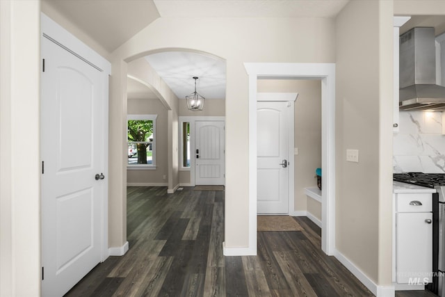 12384 S Abbott Downing Way, Nampa, ID 83686 - entrance foyer featuring dark wood-style floors, lofted ceiling, baseboards, arched walkways, and a chandelier