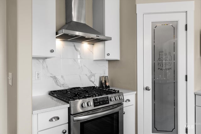 12384 S Abbott Downing Way, Nampa, ID 83686 - kitchen featuring gas range, wall chimney exhaust hood, white cabinetry, and tasteful backsplash