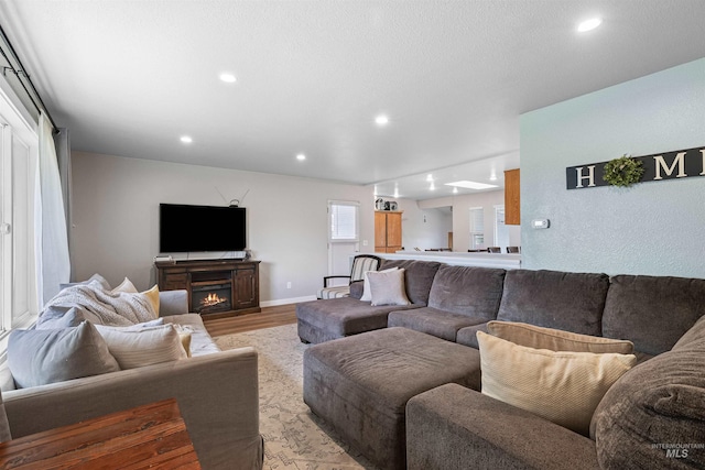 1125 Grelle Ave, Lewiston, ID 83501 - living area featuring recessed lighting, light wood-style flooring, a warm lit fireplace, and baseboards