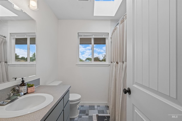 1125 Grelle Ave, Lewiston, ID 83501 - bathroom featuring vanity, tile patterned floors, toilet, baseboards, and a skylight