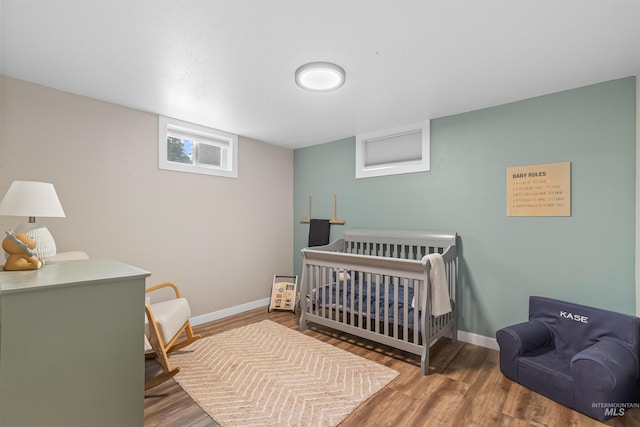 1125 Grelle Ave, Lewiston, ID 83501 - bedroom with wood finished floors, baseboards, and a nursery area