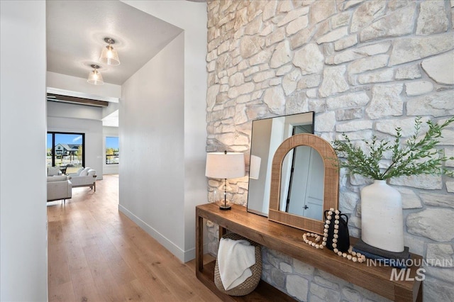 corridor featuring baseboards and hardwood / wood-style floors