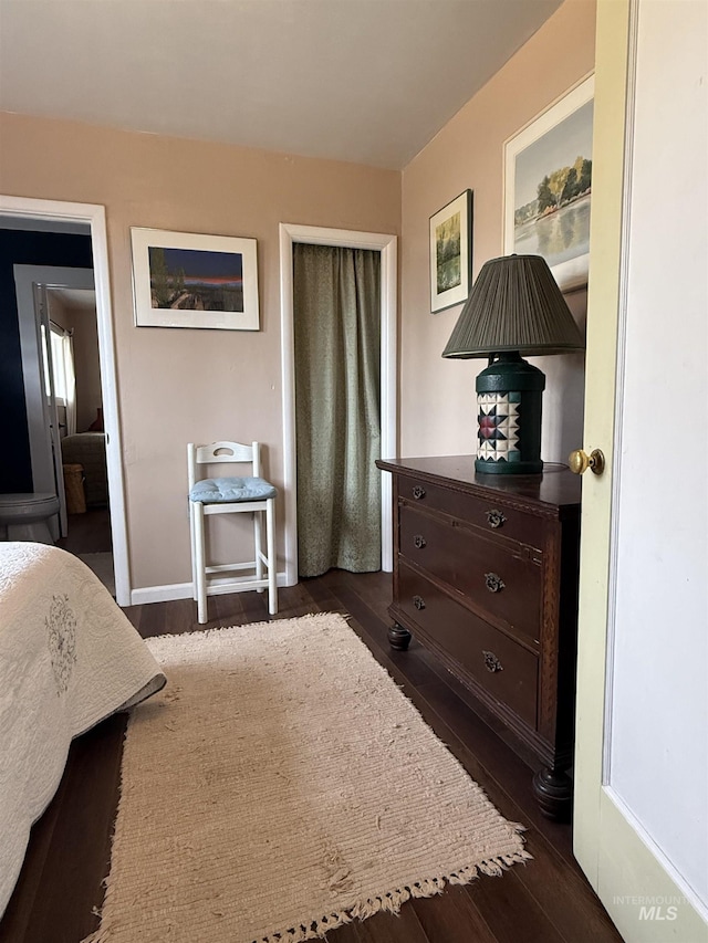 bedroom with dark wood finished floors and baseboards