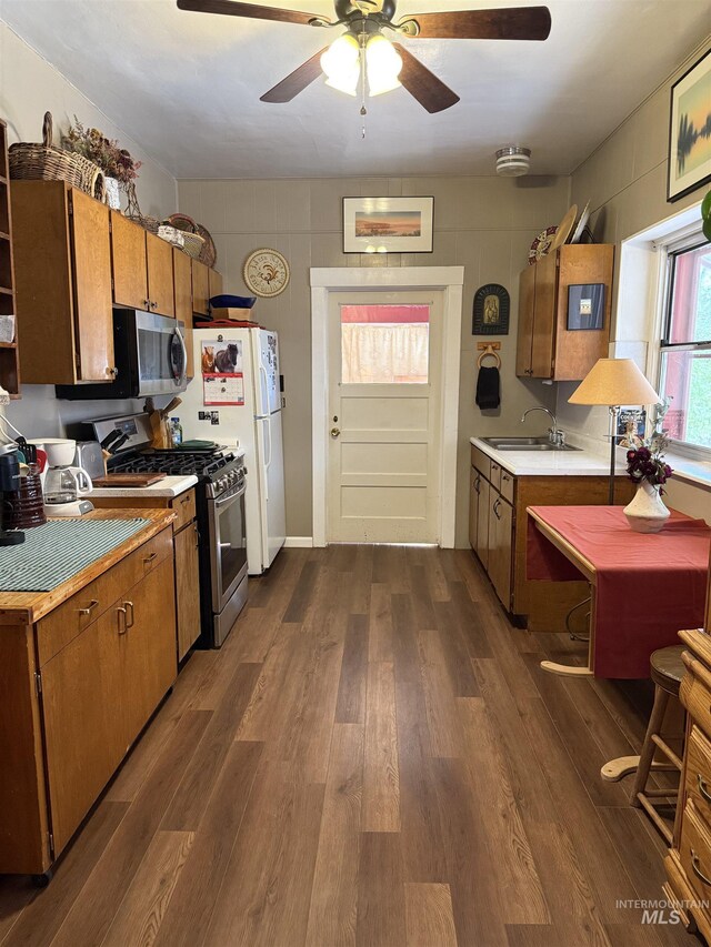 kitchen featuring appliances with stainless steel finishes, light countertops, and dark wood-type flooring