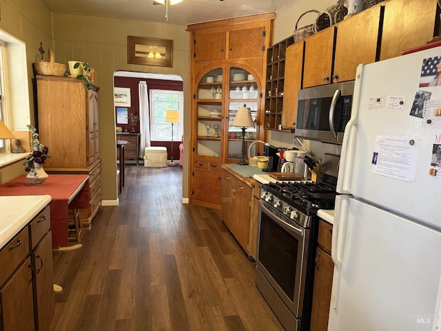kitchen featuring appliances with stainless steel finishes, dark wood-style flooring, light countertops, and brown cabinets