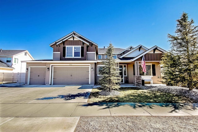 craftsman-style home featuring driveway, an attached garage, fence, and board and batten siding