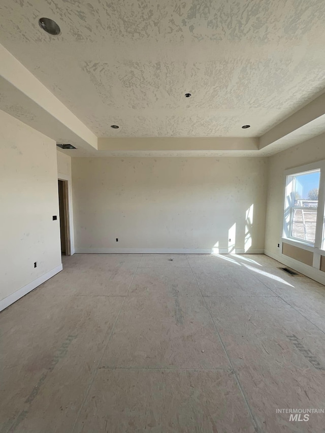 unfurnished room featuring a raised ceiling