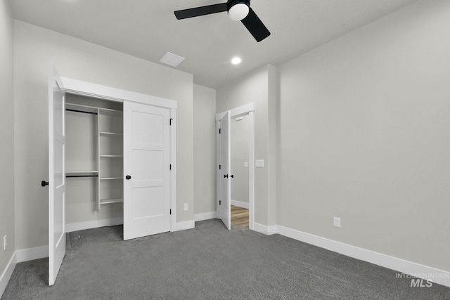 unfurnished bedroom featuring dark carpet, a closet, and ceiling fan