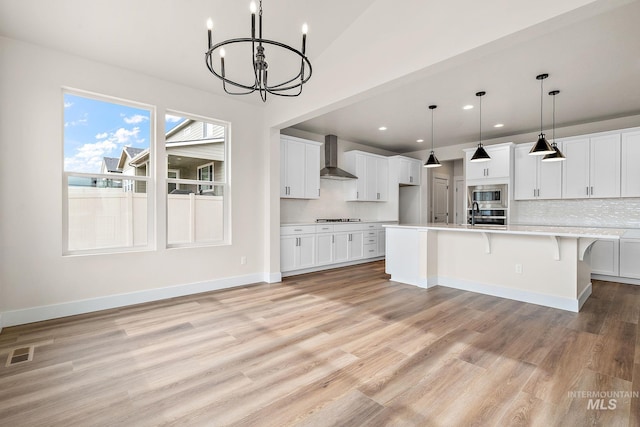 6113 N Senita Hills Ave, Meridian, ID 83646 - kitchen featuring wall chimney exhaust hood, a chandelier, light countertops, light wood finished floors, and stainless steel appliances