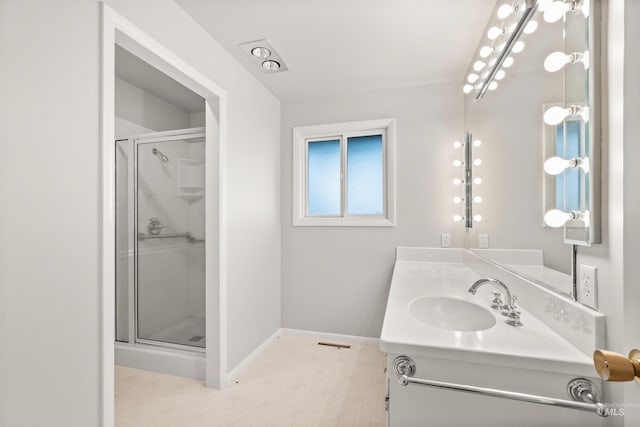 bathroom featuring a shower with door and vanity