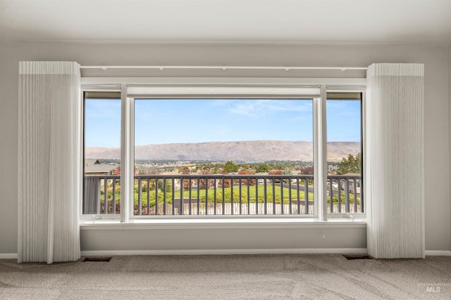 spare room with a mountain view and carpet floors