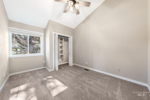 unfurnished bedroom with a closet, ceiling fan, vaulted ceiling, and light colored carpet