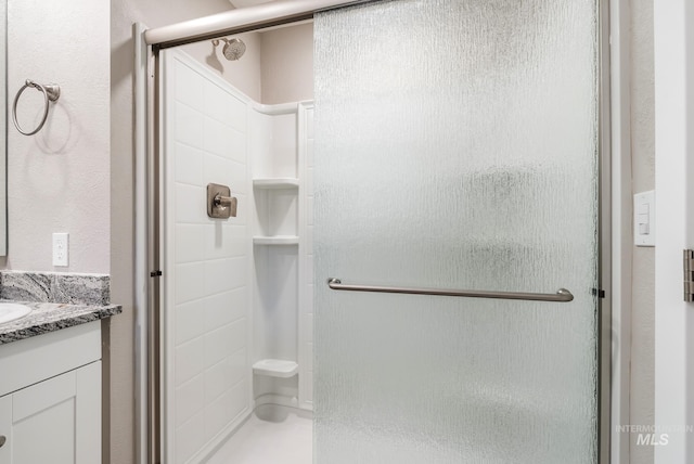 bathroom featuring vanity and a shower with door