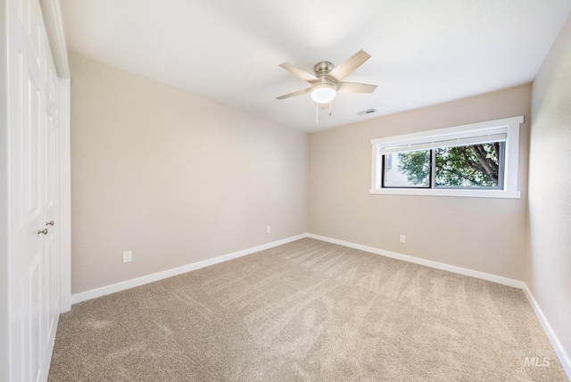 spare room featuring ceiling fan and carpet